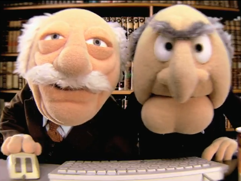 Statler and Waldorf stare into a computer screen that is the camera with mouse and keyboard